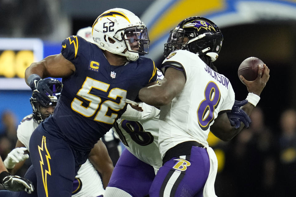 Baltimore Ravens quarterback Lamar Jackson (8) throws under pressure from Los Angeles Chargers linebacker Khalil Mack (52) during the first half of an NFL football game Sunday, Nov. 26, 2023, in Inglewood, Calif. (AP Photo/Ashley Landis)