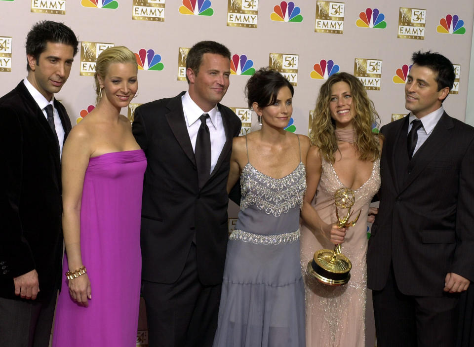 FILE - In this Sept. 22, 2002 file photo, the stars of "Friends," from left, David Schwimmer, Lisa Kudrow, Matthew Perry, Courteney Cox Arquette, Jennifer Aniston and Matt LeBlanc pose after the show won outstanding comedy series at the 54th Annual Primetime Emmy Awards, at the Shrine Auditorium in Los Angeles. If you’re a “Friends” superfan, there are lots of ways to celebrate the show’s 25th anniversary on Sept. 22, 2019. Warner Bros. has partnered with a range of companies to celebrate the quarter-century mark. (AP Photo/Reed Saxon, file)