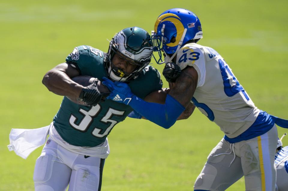 Eagles running back Boston Scott (35) is tackled by safety John Johnson.