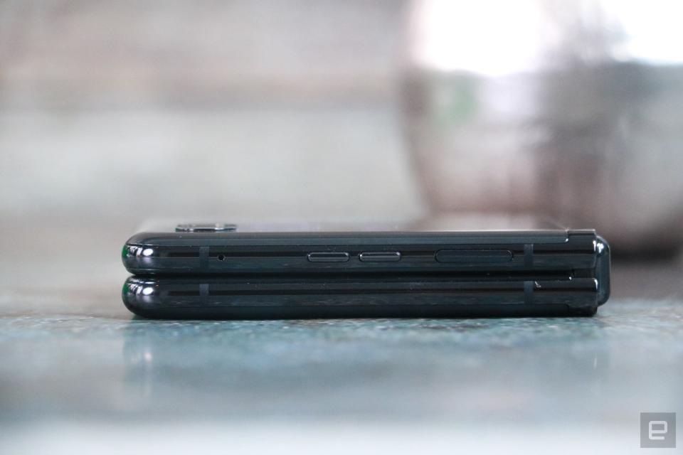 <p>Side view of the Moto Razr+ folded shut and laying flat on a table with its outside screen facing up.</p> 