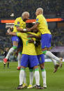 Brazil's Neymar, left and Brazil's Richarlison, right, celebrate with other team players after Vinicius Junior scored his side's opening goal during the World Cup round of 16 soccer match between Brazil and South Korea at the Stadium 974 in Doha, Qatar, Monday, Dec. 5, 2022. (AP Photo/Jin-Man Lee)