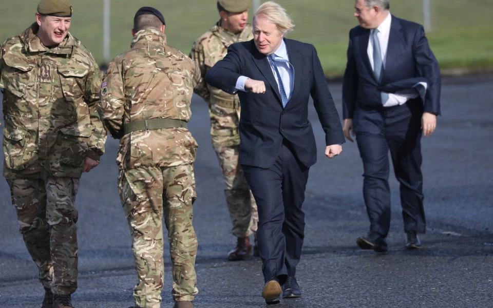 Prime Minister Boris Johnson greets troops alongside Northern Ireland Secretary Brandon Lewis (right) and Brigadier Chris Davies, Commander 38 (Irish) Brigade (left), during a visit to Joint Helicopter Command Flying Station Aldergrove in Northern Ireland -  Peter Morrison/PA