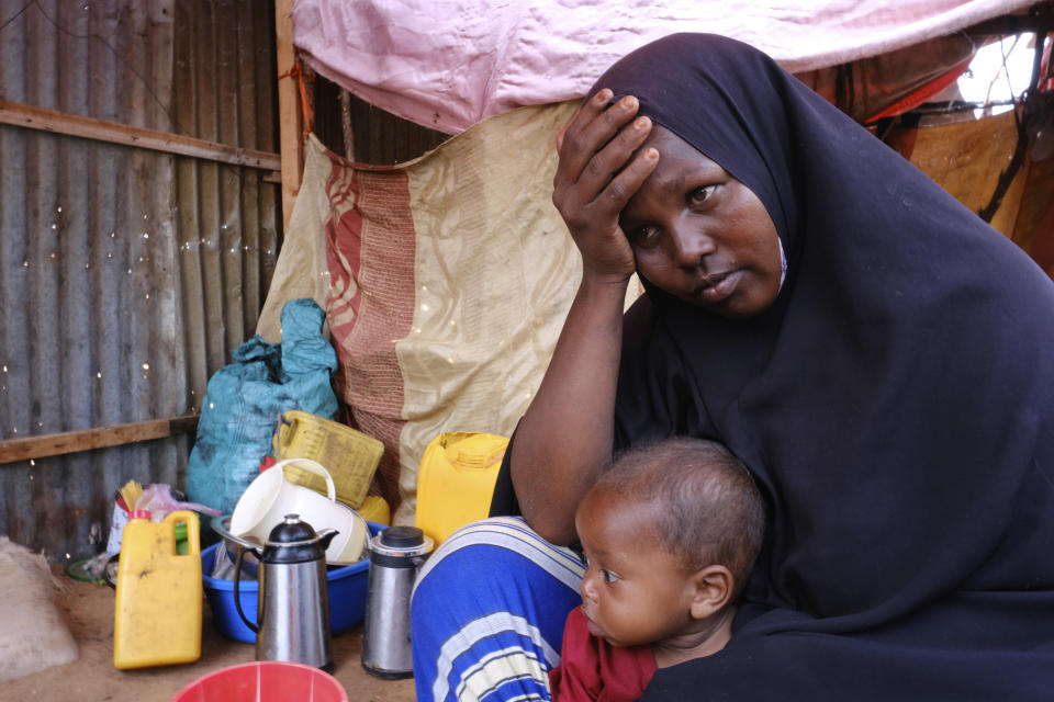 Hadiiq Abdulle Mohamed holds one of her children as she speaks during an interview with Associated Press at an internally displaced people camp on the outskirts of Mogadishu, Somalia, Friday, March 24, 2023. This year’s holy month of Ramadan coincides with the longest drought on record in Somalia. As the sun sets and Muslims around the world gather to break their daily fasts with generous dinners, Hadiiq Abdulle Mohamed and her family have just water and whatever food might be at hand. (AP Photo/Farah Abdi Warsameh)