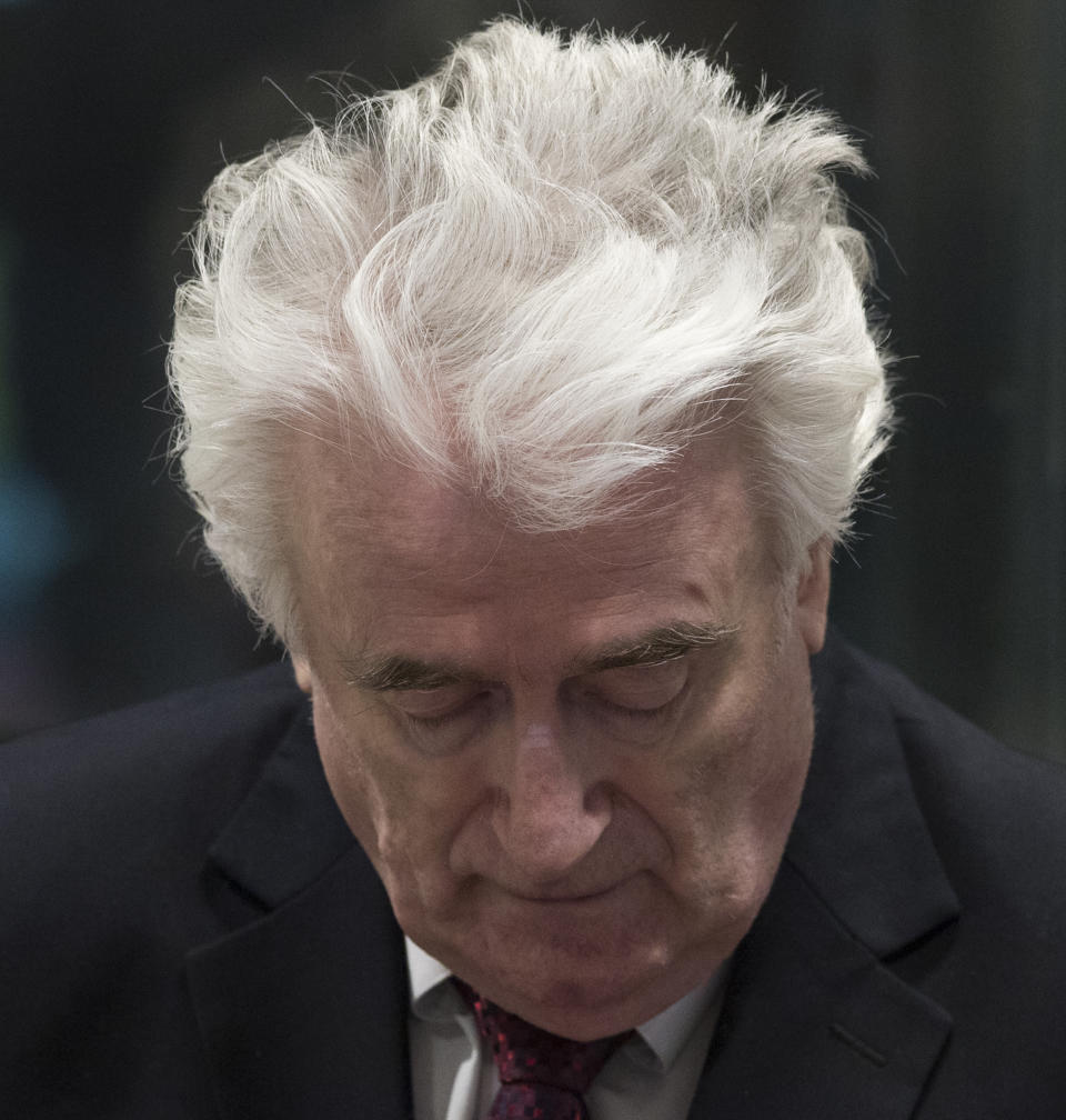 Former Bosnian Serb leader Radovan Karadzic enters the court room of the International Residual Mechanism for Criminal Tribunals in The Hague, Netherlands, Wednesday, March 20, 2019. Nearly a quarter of a century since Bosnia's devastating war ended, Karadzic is set to hear the final judgment on whether he can be held criminally responsible for unleashing a wave of murder and destruction. United Nations appeals judges will on Wednesday rule whether to uphold or overturn Karadzic's 2016 convictions for genocide, crimes against humanity and war crimes, as well as his 40-year sentence. (AP Photo/Peter Dejong, Pool)