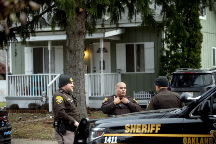 Three Oakland County Sheriff's deputies survey the grounds outside of the Crumbley residence while seeking James and Jennifer Crumbley, parents of alleged Oxford High School shooter Ethan Crumbley, on Friday, Dec. 3, 2021, in Oxford, Mich. (Jake May/The Flint Journal via AP)