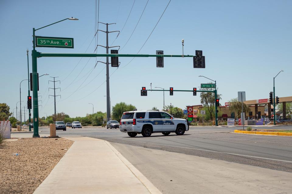 A police car blocks traffic near the site of a police shooting near 35th Avenue and Baseline Road in Phoenix on June 14, 2022.