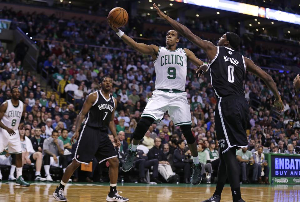 Boston Celtics guard Rajon Rondo (9) drives to the basket between Brooklyn Nets guards Deron Williams (8) and Joe Johnson (7) during the second quarter of an NBA basketball game, Friday, March 7, 2014, in Boston. (AP Photo/Charles Krupa)