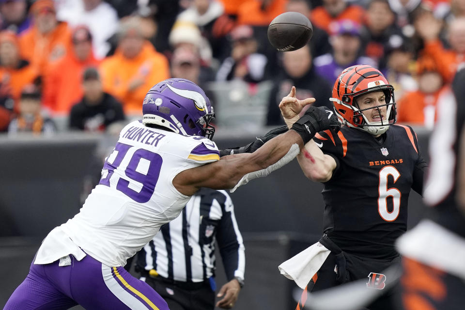 Cincinnati Bengals quarterback Jake Browning (6) throws as he is hit by Minnesota Vikings linebacker Danielle Hunter (99) during the second half of an NFL football game Saturday, Dec. 16, 2023, in Cincinnati. (AP Photo/Carolyn Kaster)