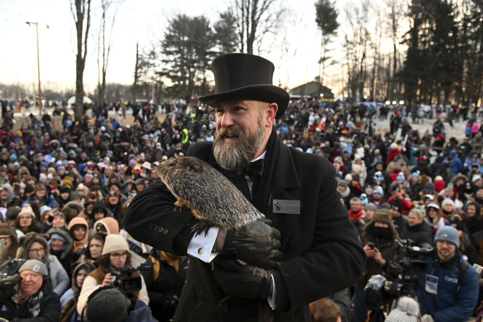 Groundhog Club handler A.J. Dereume holds Punxsutawney Phil, the weather prognosticating groundhog, during the 137th celebration of Groundhog Day on Gobbler's Knob in Punxsutawney, Pa., Thursday, Feb. 2, 2023. Phil's handlers said that the groundhog has forecast six more weeks of winter. (AP Photo/Barry Reeger)