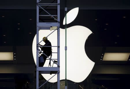 A worker climbs outside an Apple store in Hong Kong, China, in this April 10, 2013 file photo. REUTERS/Bobby Yip/Files