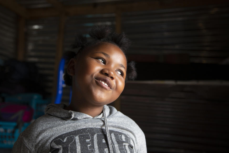 En esta imagen, tomada el 28 de abril de 2020, Lilitha Jiphethu, de 11 años, canta en su lengua materna, el xhosa, en su casa en Orange Farm, Sudáfrica. “Tengo un amigo en Jesús”, canta. “Él es amoroso y es como ningún otro amigo. “Él no es deshonesto. No se avergüenza de nosotros. Él es sincero y Él es amor". (AP Foto/Denis Farrell)