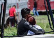 <p>A man and woman embrace as they look at the site of a series of explosions at fireworks warehouses in Tultepec, central Mexico, on July 5, 2018. – At least 17 people were killed, including rescue workers who died saving others’ lives, officials said. The initial explosion occurred around 9:30 am (1430 GMT), then spread to other warehouses just as police and firefighters began attending to the first victims. (Photo: Pedro Pardo/AFP/Getty Images) </p>