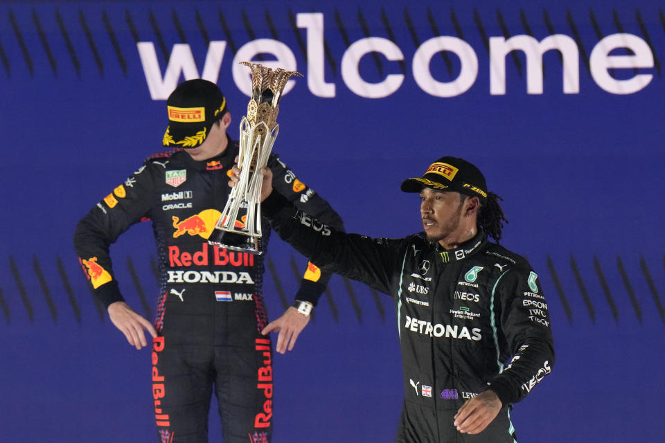 El piloto británico Lewis Hamilton de Mercedes celebra tras ganar el Gran Premio de Fórmula Uno de Arabia Saudita, junto al piloto neerlandés Max Verstappen de Red Bull, que quedó el segundo lugar, el domingo 5 de diciembre de 2021 en Yeda, Arabia Saudita. (AP Foto/Hassan Ammar)
