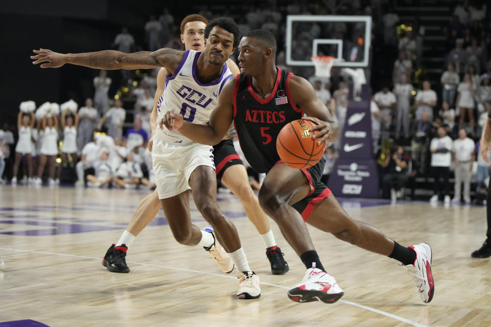 San Diego State guard Lamont Butler (5) drives on Grand Canyon guard Ray Harrison during the first half of an NCAA college basketball game Tuesday, Dec. 5, 2023, in Phoenix. (AP Photo/Rick Scuteri)