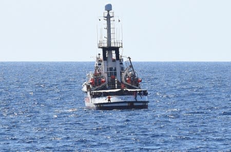 Migrants jump off the Spanish rescue ship Open Arms, close to the Italian shore in Lampedusa