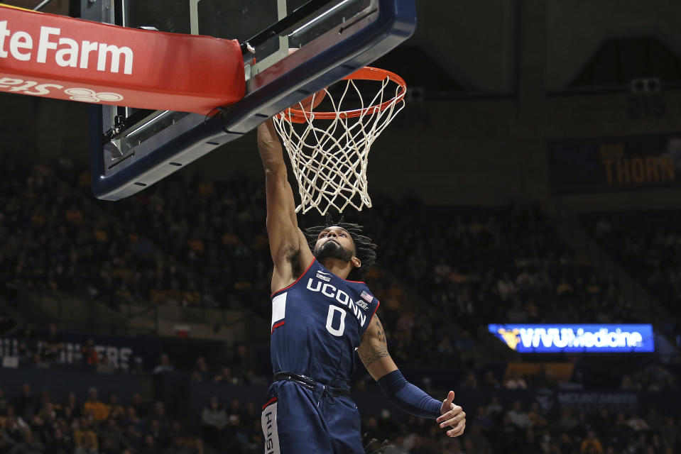 Connecticut guard Jalen Gaffney dunks against West Virginia during the first half of an NCAA college basketball game in Morgantown, W.Va., Wednesday, Dec. 8, 2021. (AP Photo/Kathleen Batten)