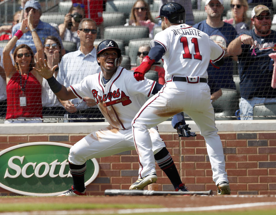 Atlanta Braves' Ronald Acuna Jr., left, and Ender Inciarte (11) celebrate after scoring on a two-run base hit by Freddie Freeman in the second inning of a baseball game against the Philadelphia Phillies, Saturday, Sept. 22, 2018, in Atlanta. (AP Photo/John Bazemore)