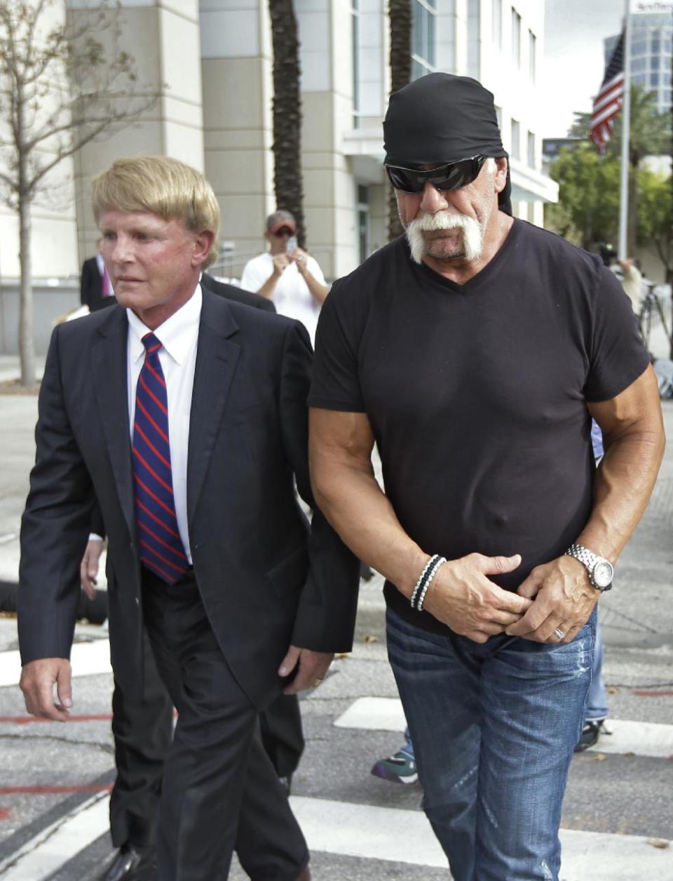 Reality TV star and former pro wrestler Hulk Hogan, right, whose real name is Terry Bollea, leaves the United States Courthouse with his attorney David Houston after a news conference Monday, Oct. 15, 2012 Tampa, Fla. Hogan says he was secretly taped six years ago having sex with the ex-wife of DJ Bubba "The Love Sponge" Clem. Portions of the video of Hogan and Heather Clem were posted on the online gossip site Gawker. (AP Photo/Chris O'Meara)