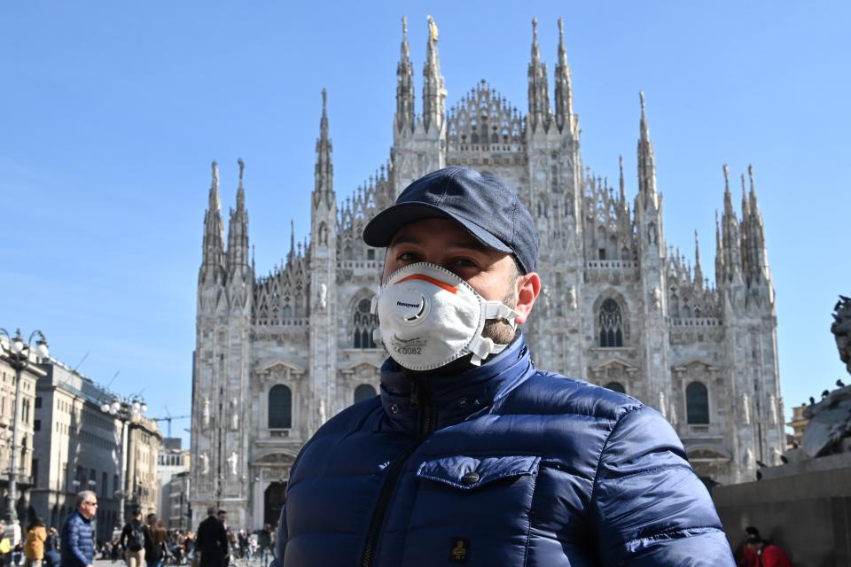 A man wearing a protective facemask walks across the Piazza del Duomo, in front of the Duomo, in central Milan, on February 24, 2020 closed following security measures taken in northern Italy against the COVID-19 the novel coronavirus. - Italy reported on February 24, 2020 its fourth death from the new coronavirus, an 84-year old man in the northern Lombardy region, as the number of people contracting the virus continued to mount. (Photo by Andreas SOLARO / AFP) (Photo by ANDREAS SOLARO/AFP via Getty Images)