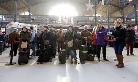 Travellers wait with their luggage at the Gare du Nord train station after a power outage that has suspended main line services, including the Eurostar, RER commuter trains and suburban train services at the station in Paris, France, December 7, 2016. REUTERS/Yves Herman