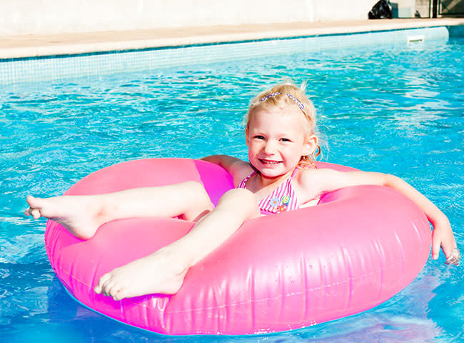 Niña flotando en el agua con un fotador