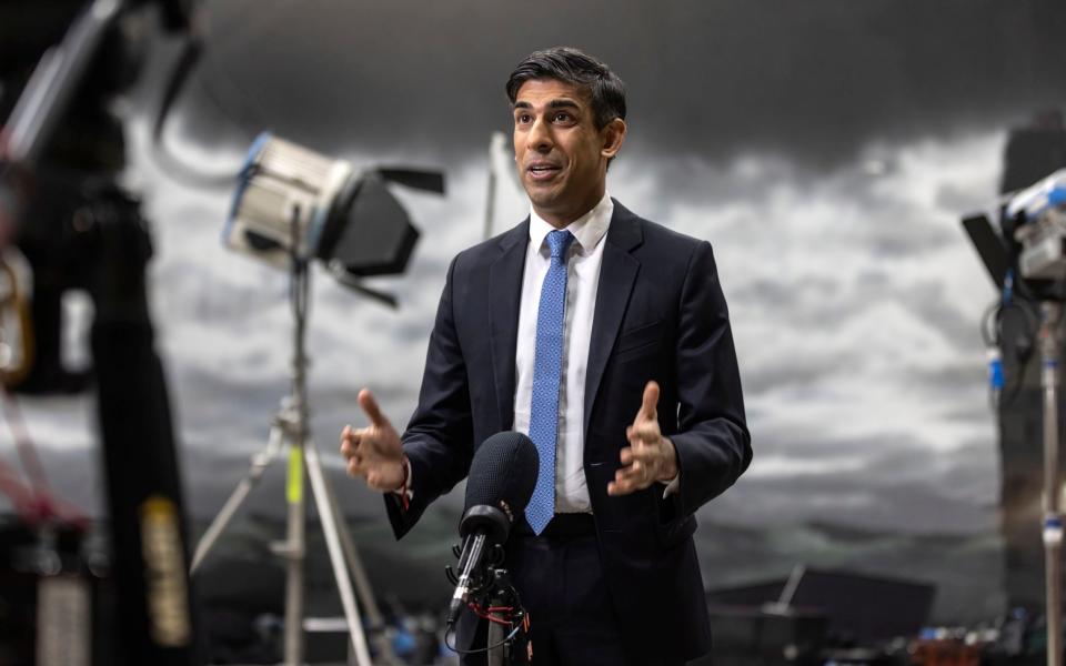 Rishi Sunak speaks during a TV interview in front of a painted back drop of a stormy sky created by students at the National Film and Television school in Beaconsfield
