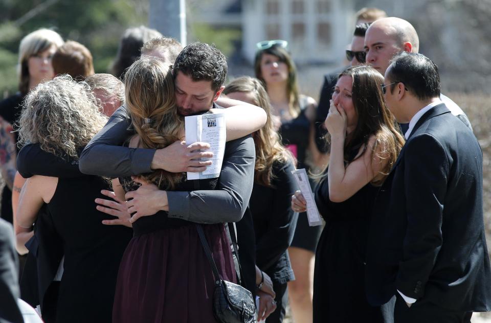 Friends and family hug after the funeral of Josh Hunter in Calgary, Alberta, April 21, 2014. Matthew de Grood is charged with killing Hunter and four of his friends at a house party in Calgary's worst mass murder in the history of the city, according to local media reports. REUTERS/Todd Korol (CANADA - Tags: CRIME LAW OBITUARY)