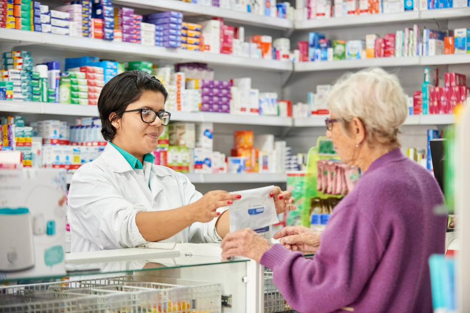 Shot of a female chemist handing over the medicine packet to senior women at pharmacy