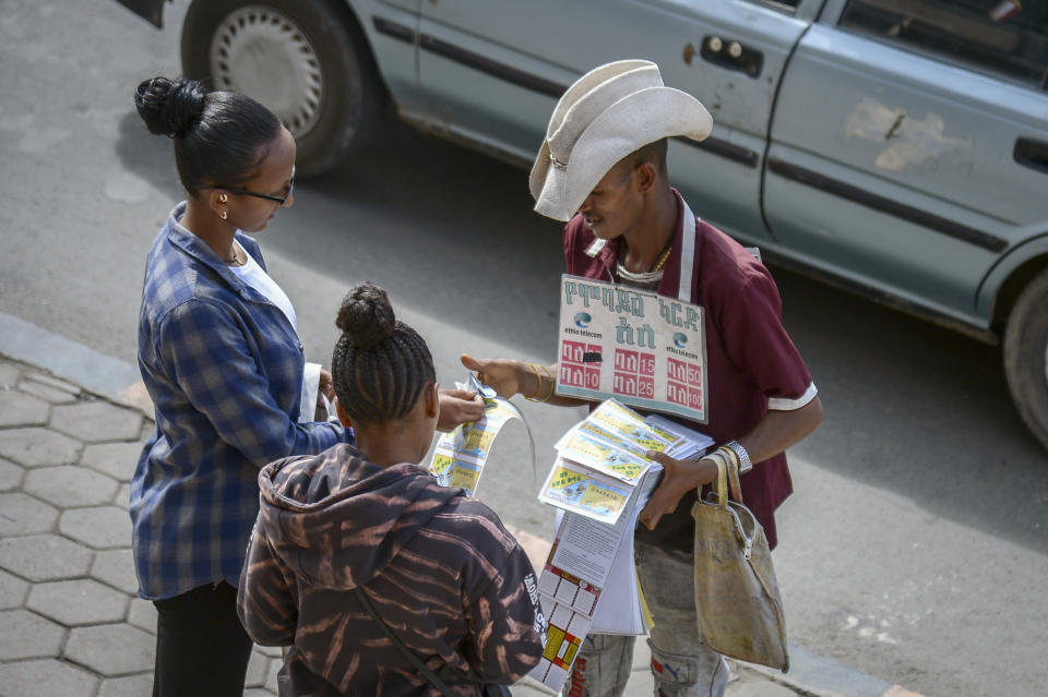 A vendor sells mobile phone credit scratch cards and lottery tickets on a street in Addis Ababa, Ethiopia Thursday, Nov. 3, 2022. Ethiopia's warring sides agreed Wednesday to a permanent cessation of hostilities in a conflict believed to have killed hundreds of thousands, but enormous challenges lie ahead, including getting all parties to lay down arms or withdraw. (AP Photo)
