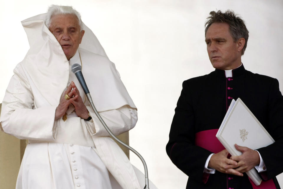 FILE - A gust of wind blows Pope Benedict XVI's cloak as he prays, flanked by his personal aide Rev. Georg Gaenswein, during his weekly general audience at the Vatican, Wednesday, Oct. 20, 2010. Pope Francis met on Monday, Jan. 9, 2023, with Archbishop Gaenswein, the longtime secretary of Pope Benedict XVI who was a key figure in his recent funeral but who has raised eyebrows with an extraordinary memoir in which he settles old scores and reveals palace intrigue. (AP Photo/Pier Paolo Cito, File)