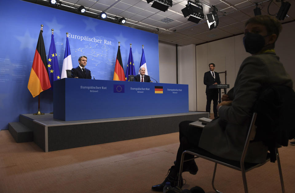 French President Emmanuel Macron, left, and German Chancellor Olaf Scholz, center, address a media conference at the conclusion of an EU Summit in Brussels, Friday, Dec. 17, 2021. European Union leaders met for a one-day summit Thursday focusing on Russia's military threat to neighbouring Ukraine and on ways to deal with the continuing COVID-19 crisis. (John Thys, Pool Photo via AP)