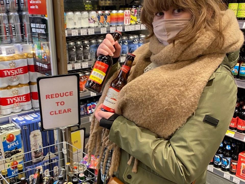 alexis holding bottles of american beer at an irish supermarket