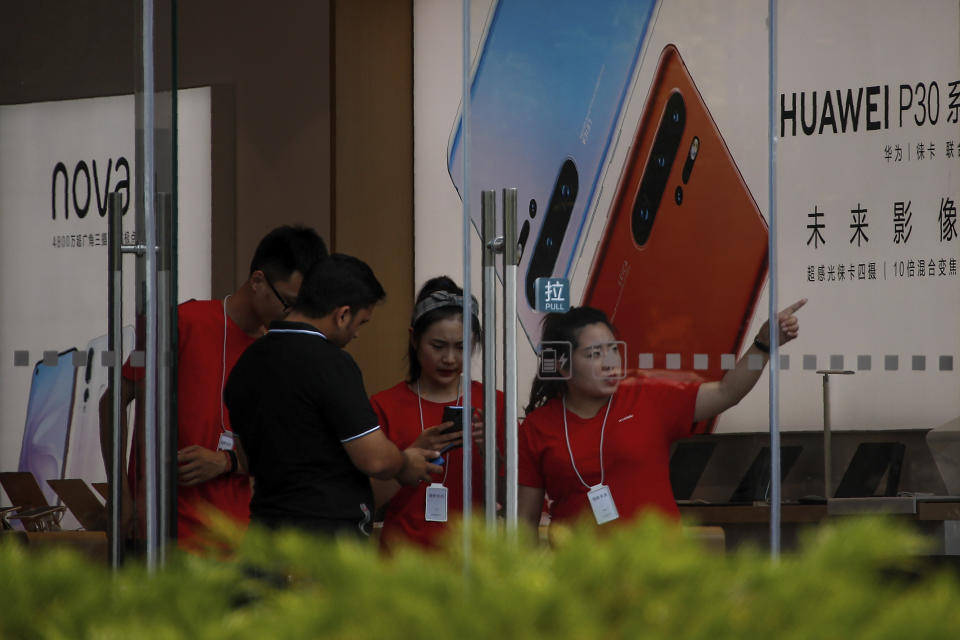 Staffers help a tourist search for directions at a Huawei retail store in Beijing, Tuesday, June 11, 2019. Chinese tech giant Huawei said Tuesday it would have become the world's number one smartphone maker by year's end if it were not for "unexpected" circumstances — a hint that pressure from the U.S. may be hurting its sales. (AP Photo/Andy Wong)