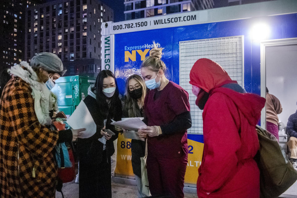 FILE - People check their rapid COVID-19 test results outside of a testing site on the Lower East Side of Manhattan, on Dec. 21, 2021, in New York. The World Health Organization said Friday May 5, 2023 that COVID-19 no longer qualifies as a global emergency, marking a symbolic end to the devastating coronavirus pandemic that triggered once-unthinkable lockdowns, upended economies and killed millions of people worldwide. (AP Photo/Brittainy Newman, File)