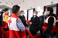 Chinese Ambassador to Italy, Li Junhua, center, talks to a team of Chinese medical experts prior to a news conference at the Red Cross headquarters in Rome, Friday, March 13, 2020. Italy has welcomed a team of Chinese medical experts and 31 tons of ventilators, protective masks and other medical equipment as its fight against coronavirus turns a nation that usually donates aid into one that receives it. For most people, the new coronavirus causes only mild or moderate symptoms. For some it can cause more severe illness. (Alfredo Falcone/LaPresse via AP)
