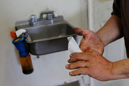 Fred Stone washes his hands while working on his dairy farm, after discovering the soil, hay, and the milk from the cows contain extremely high levels of PFAS chemicals resulting from a 1980's state program to fertilize the pastures with treated sludge waste and making the milk unsuitable for sale, at the Stoneridge Farm in Arundel, Maine, U.S., March 11, 2019. Picture taken March 11, 2019. REUTERS/Brian Snyder