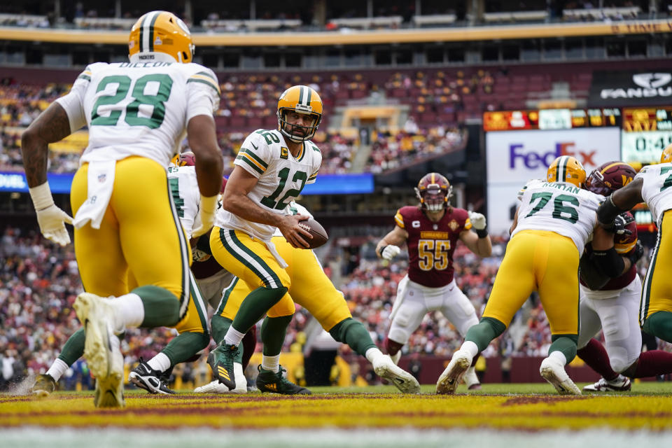Green Bay Packers quarterback Aaron Rodgers (12) prepares to hand the ball off to running back AJ Dillon (28)during the first half of an NFL football game against the Washington Commanders, Sunday, Oct. 23, 2022, in Landover, Md. (AP Photo/Patrick Semansky)