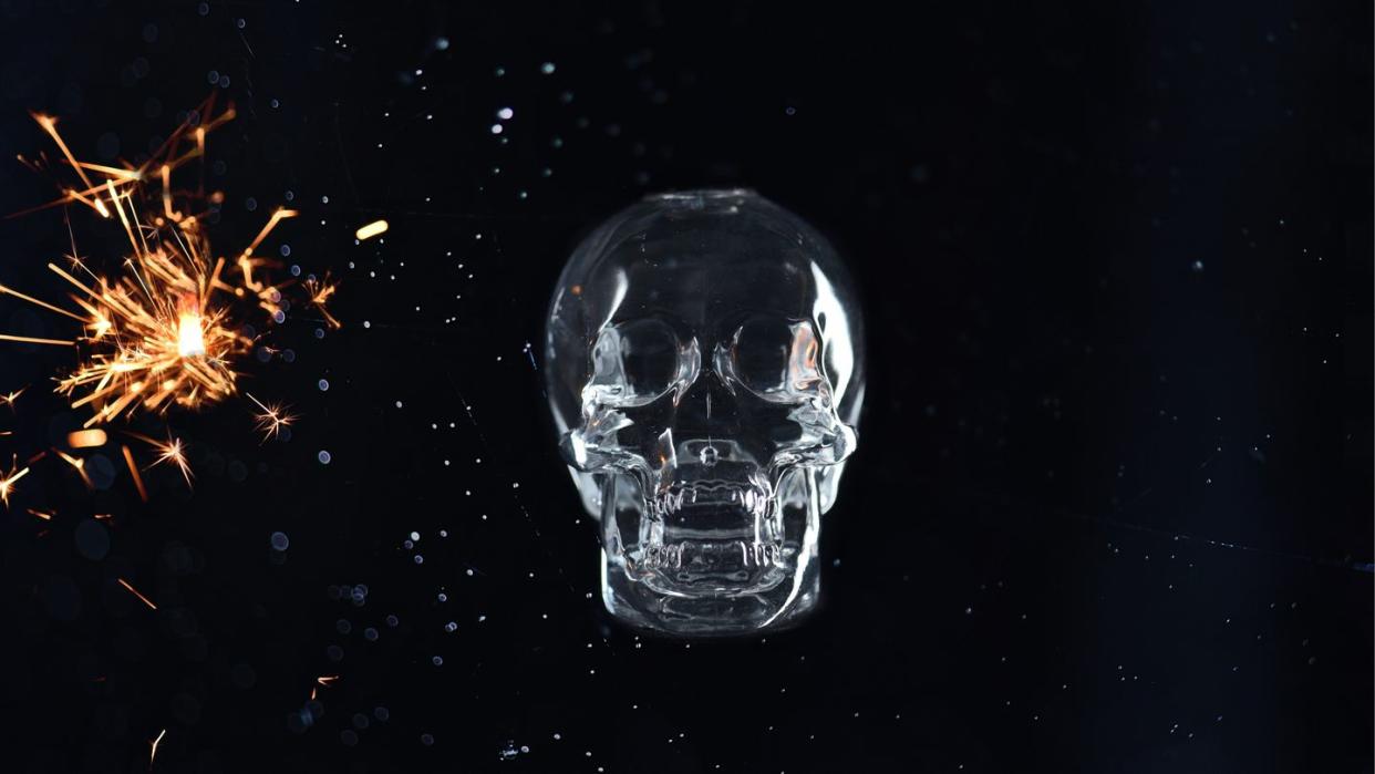 human skull with sparks over black background