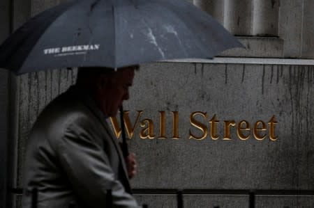 A man walks through the rain on Wall St. outside the NYSE in New York