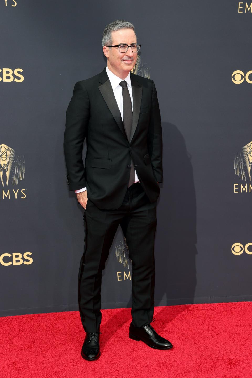 John Oliver wears a black suit on the Emmys red carpet.