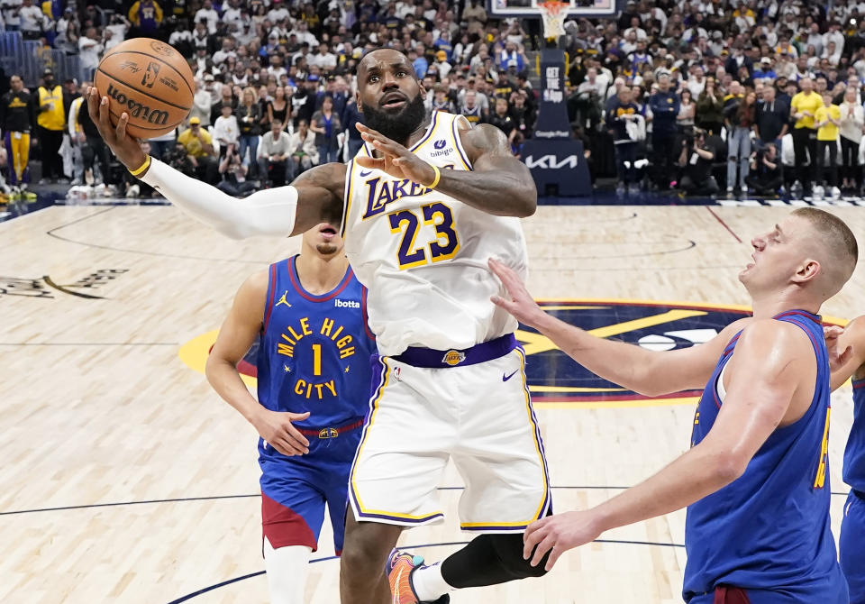 Los Angeles Lakers forward LeBron James (23) goes up to shoot against Denver Nuggets center Nikola Jokic, right, during the second half in Game 1 of an NBA basketball first-round playoff series, Saturday, April 20, 2024, in Denver. (AP Photo/Jack Dempsey)