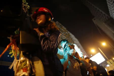 Pro-democracy protesters stand by a barricade as they prepare for a confrontation with riot police at the Mongkok shopping district of Hong Kong October 20, 2014. REUTERS/Carlos Barria