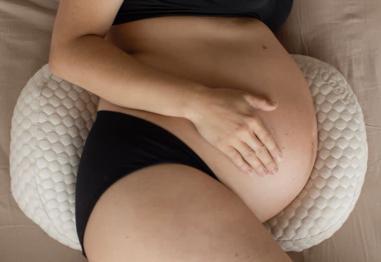 Pregnant model on Sleepybelly Pregnancy Pillow