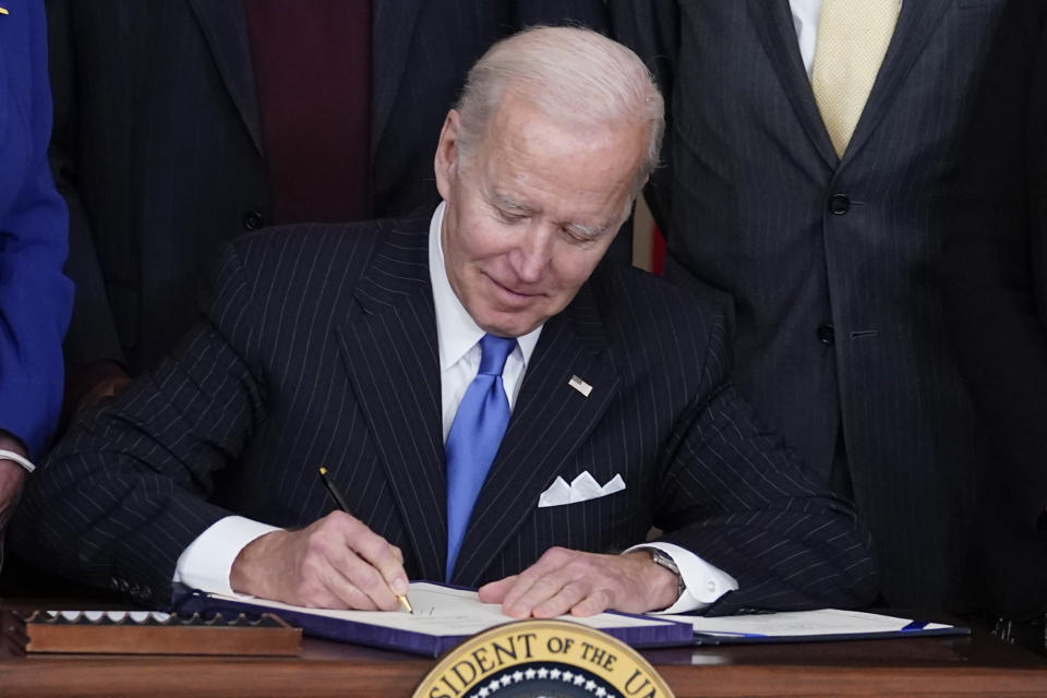 President Joe Biden signs the Postal Service Reform Act of 2022 in the State Dining Room at the White House in Washington, Wednesday, April 6, 2022. The long-fought postal overhaul has been years in the making. It comes amid widespread complaints about mail service slowdowns. (AP Photo/Susan Walsh)