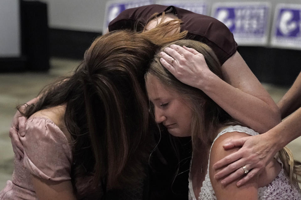 Hannah Joerger, left, Amanda Grosserode, center, and Mara Loughman hug during a Value Them Both watch party after a question involving a constitutional amendment removing abortion protections from the Kansas constitution failed Tuesday, Aug. 2, 2022, in Overland Park, Kan. (AP Photo/Charlie Riedel)