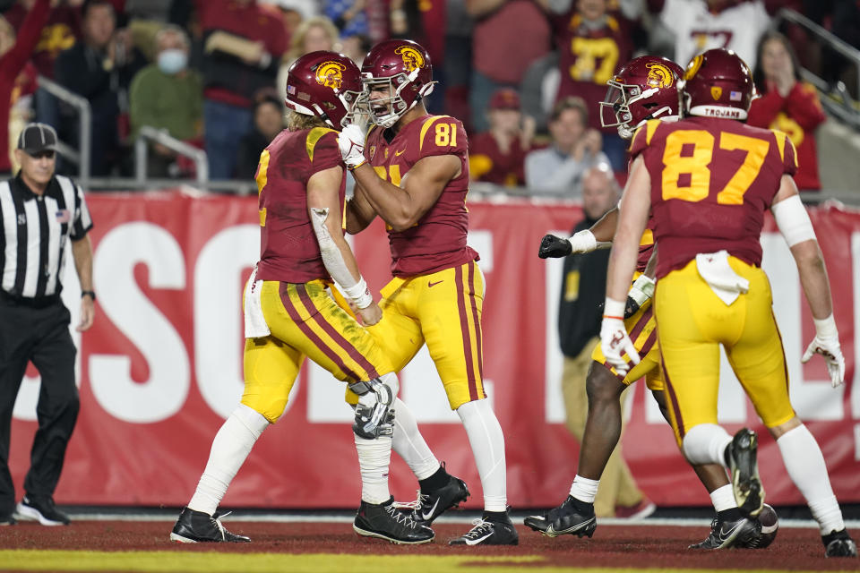 Southern California quarterback Jaxson Dart, left, celebrates with wide receiver Kyle Ford (81) after running to the end zone for a touchdown during the first half of an NCAA college football game against Brigham Young in Los Angeles, Saturday, Nov. 27, 2021. (AP Photo/Ashley Landis)