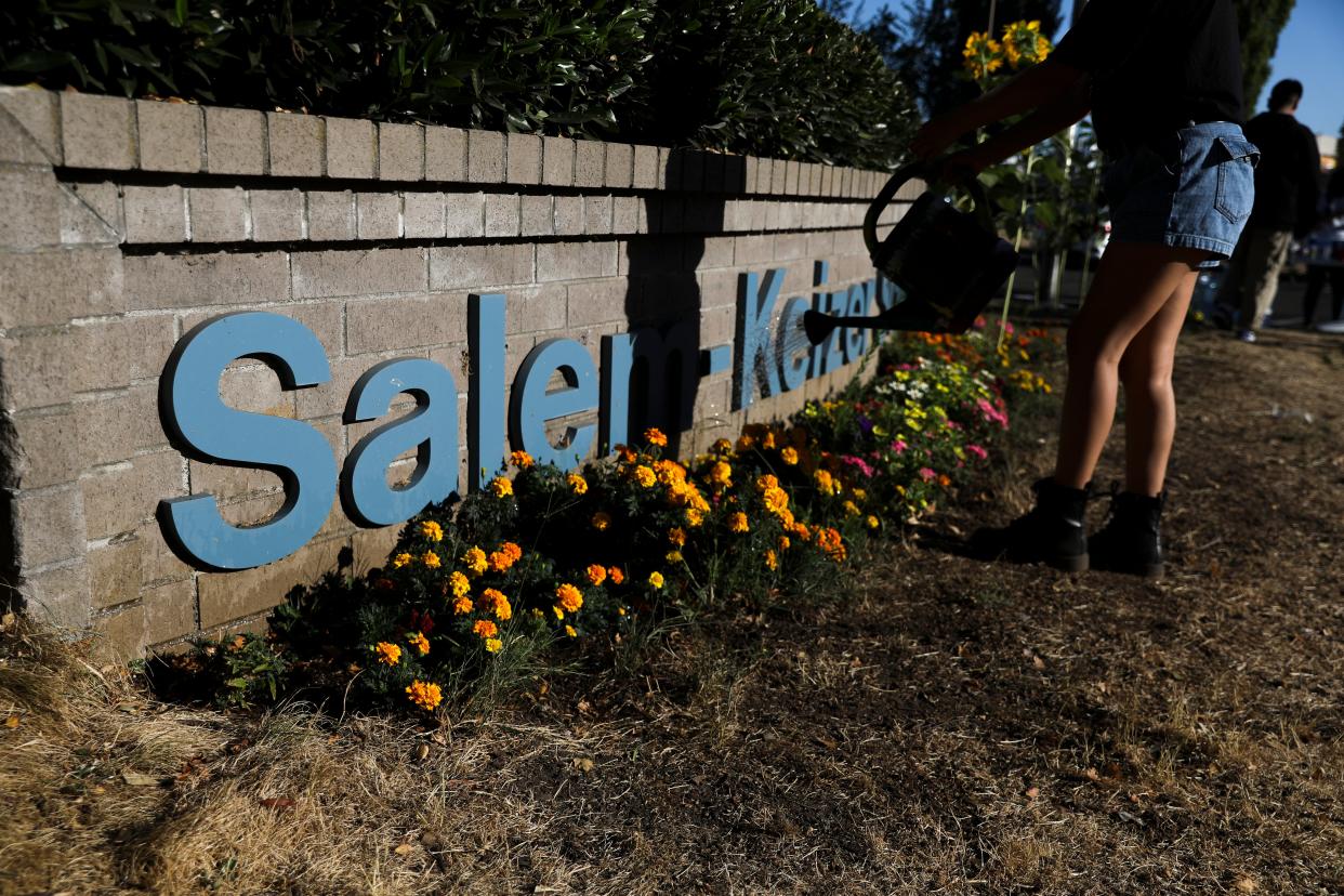 Youth activists Tabitha A., 18, waters the flowers that Latinos Unidos Siempre planned in May, at the Salem-Keizer School district building in Salem, Ore. on Tuesday, Sept. 14, 2021.