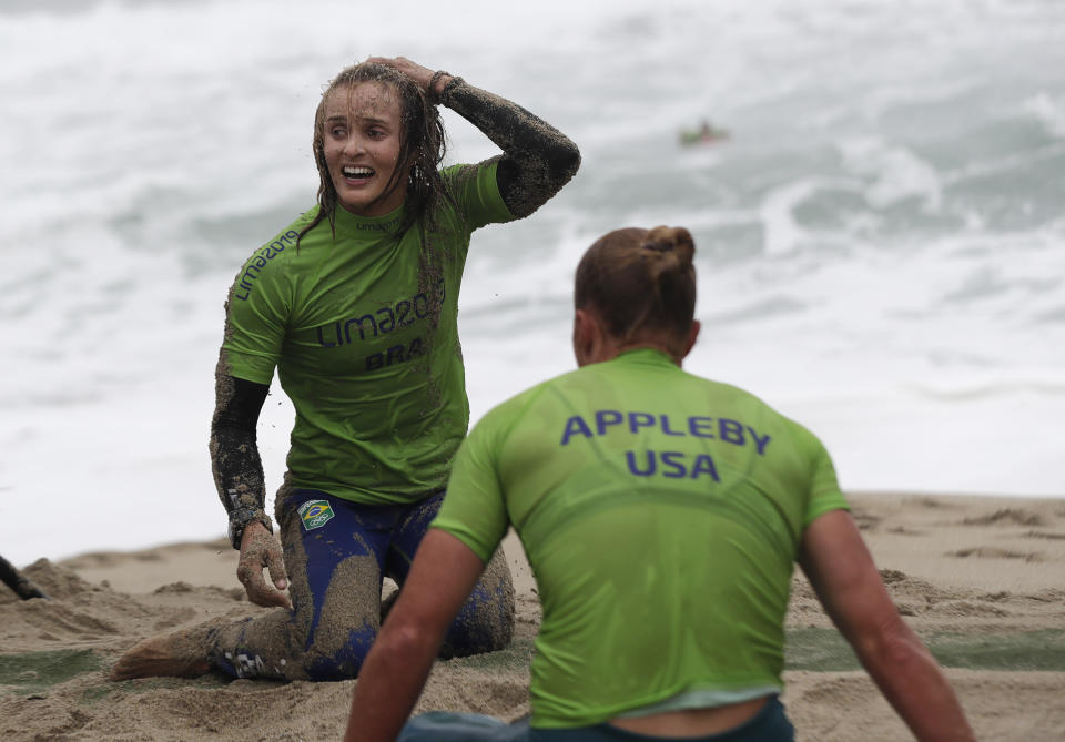 Gold medal Brazil's Lena Guimaraes, left, and Silver medal Candice Appleby of the United States sit on the sand after finishing the women's SUP race final during the Pan American Games on Punta Rocas beach in Lima Peru, Friday, Aug.2, 2019. (AP Photo/Silvia Izquierdo)