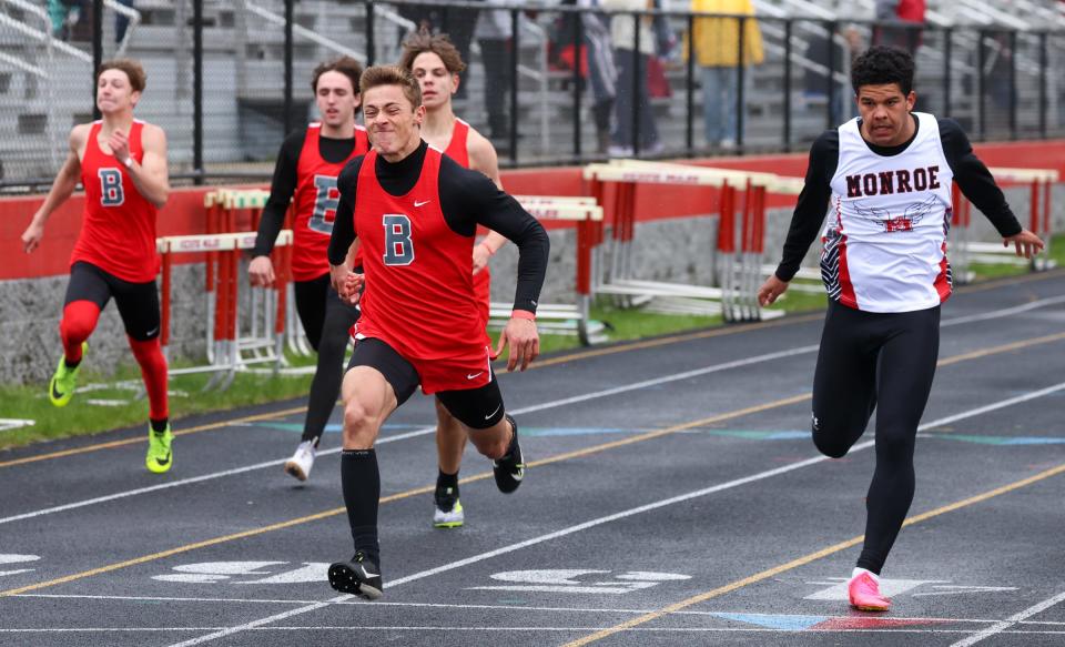 Zackery Scoble of Bedford holds off Monroe's Teegan Simmons to win the 100 meters Tuesday.