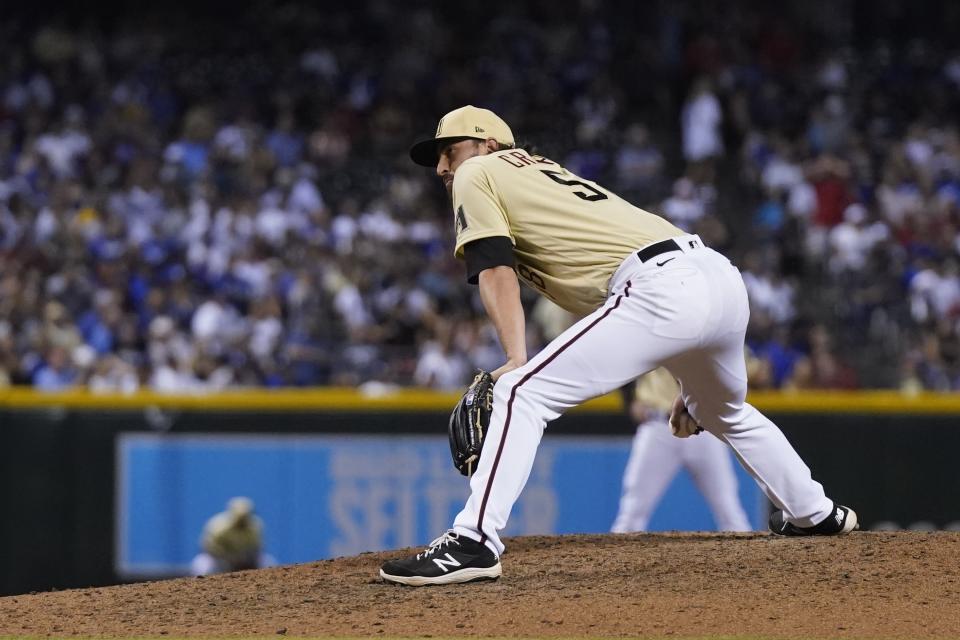 Arizona Diamondbacks relief pitcher Stefan Crichton pauses on the mound after giving up a run on a balk during the eighth inning of the team's baseball game against the Los Angeles Dodgers on Friday, June 18, 2021, in Phoenix. The Dodgers won 3-0. (AP Photo/Ross D. Franklin)